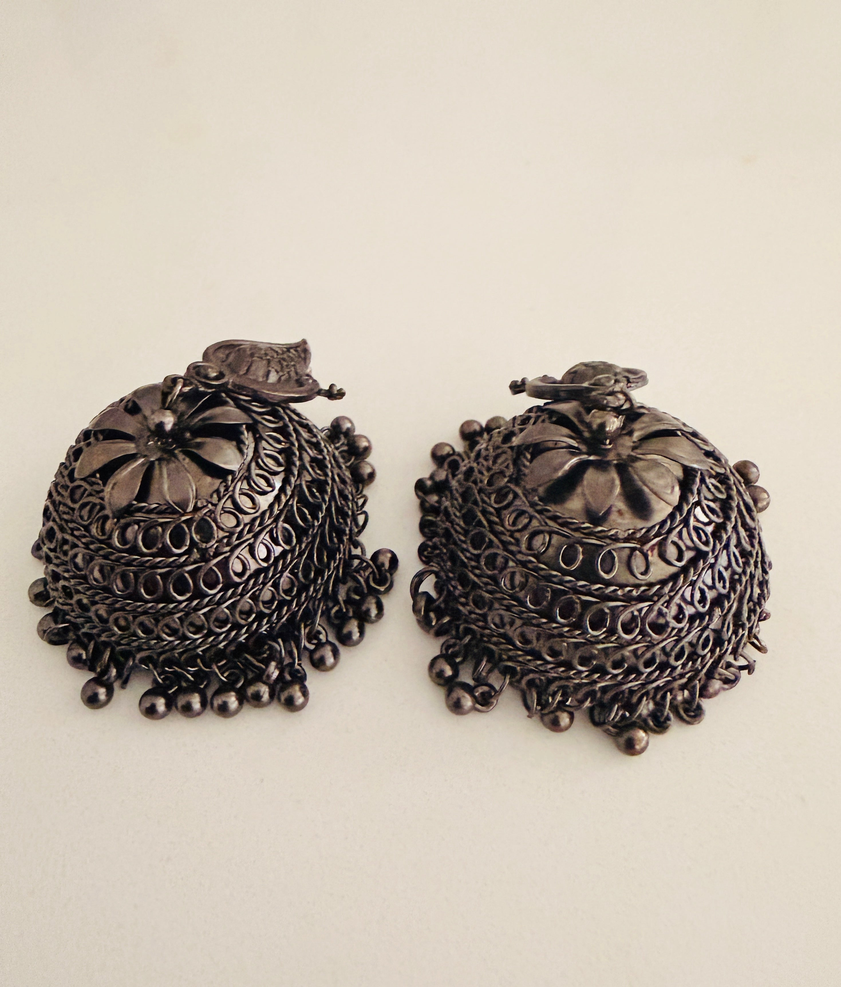 Bohemian-style oxidized silver dangle earrings featuring blue rhinestone centers and beaded tassels