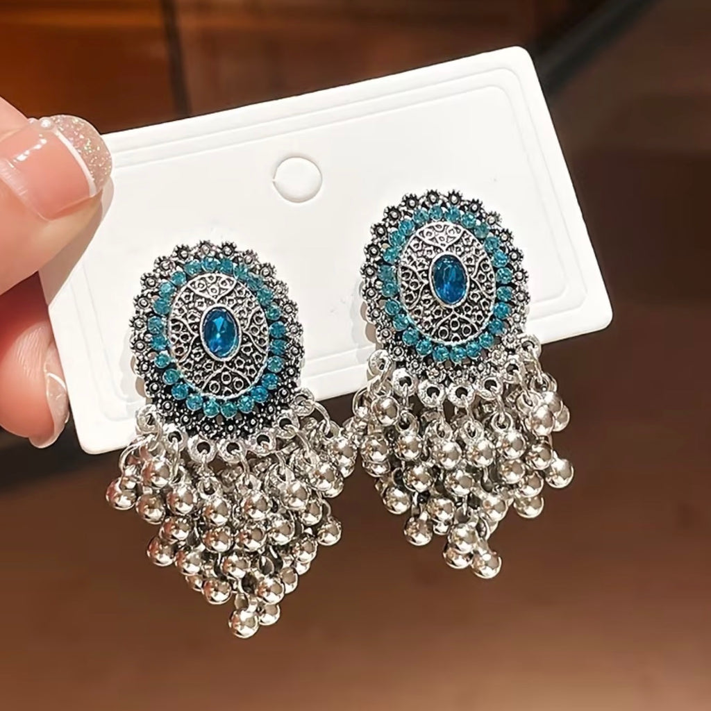 Bohemian-style oxidized silver dangle earrings featuring blue rhinestone centers and beaded tassels