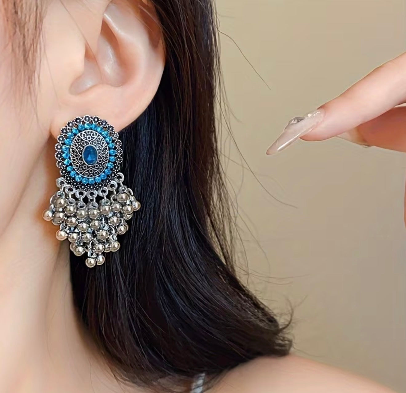 Bohemian-style oxidized silver dangle earrings featuring blue rhinestone centers and beaded tassels